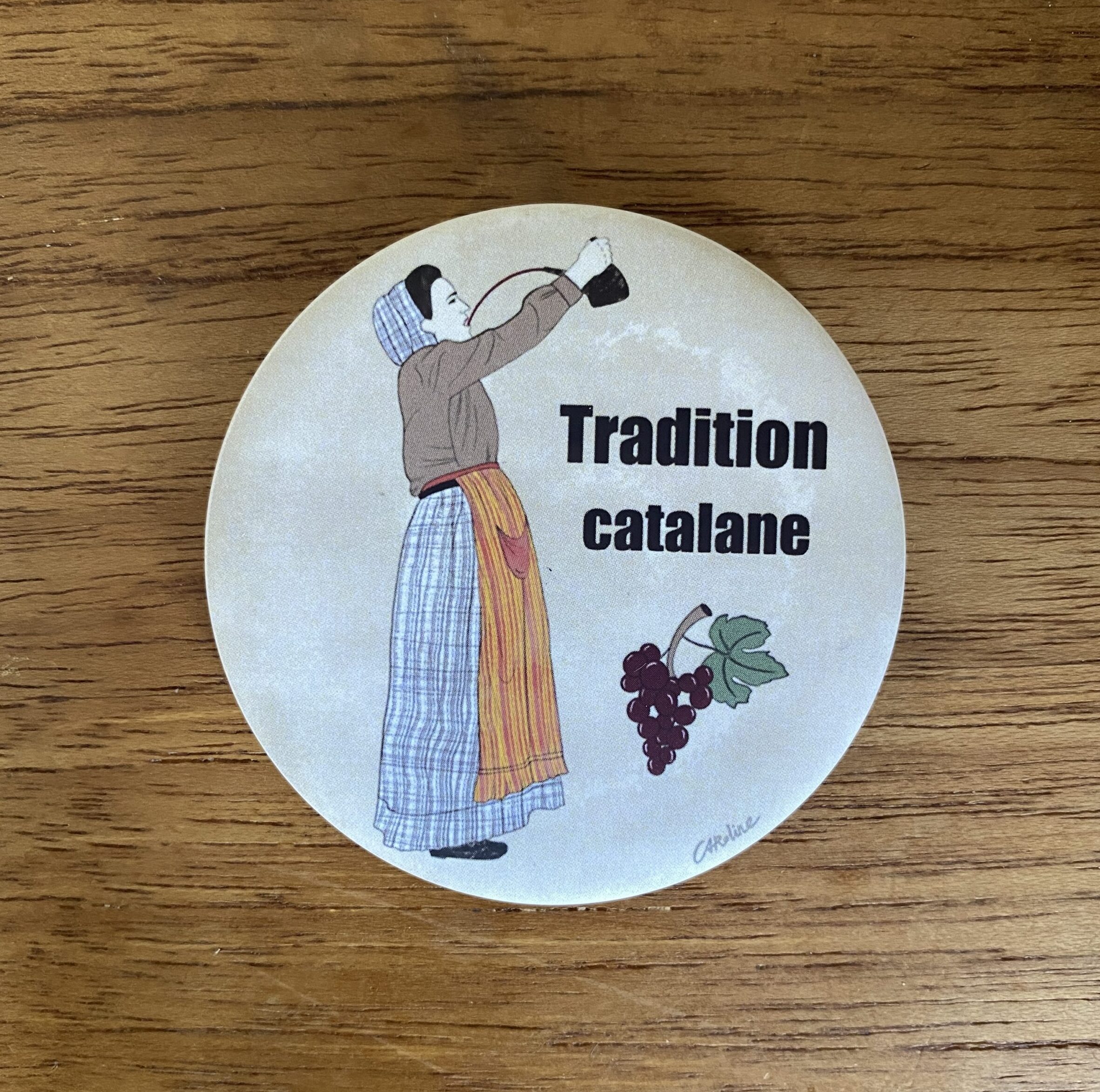 Magnet représentant une femme en costume traditionnel catalan avec une grappe de raisin, illustration de Caroline Duboc