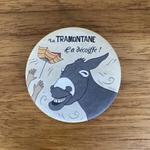 Magnet représentant un âne catalan emporté par la tramontane avec un drapeau catalan, illustration de Caroline Duboc